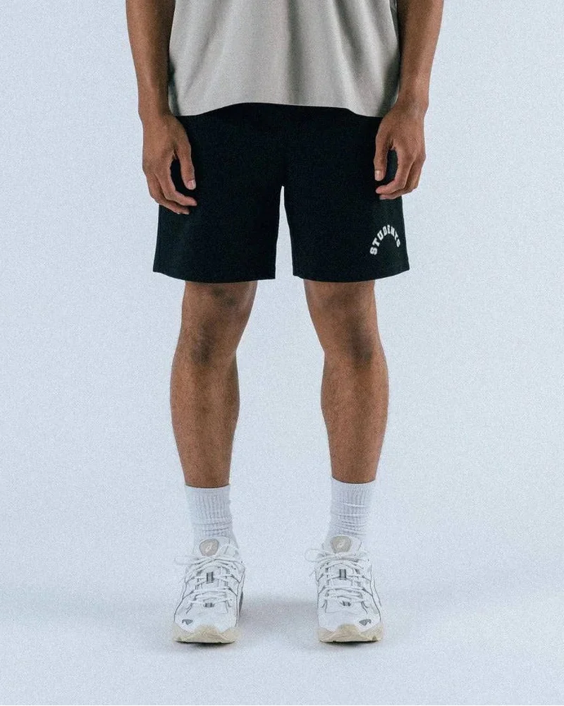 Man with blue shorts and tan shirt on white background