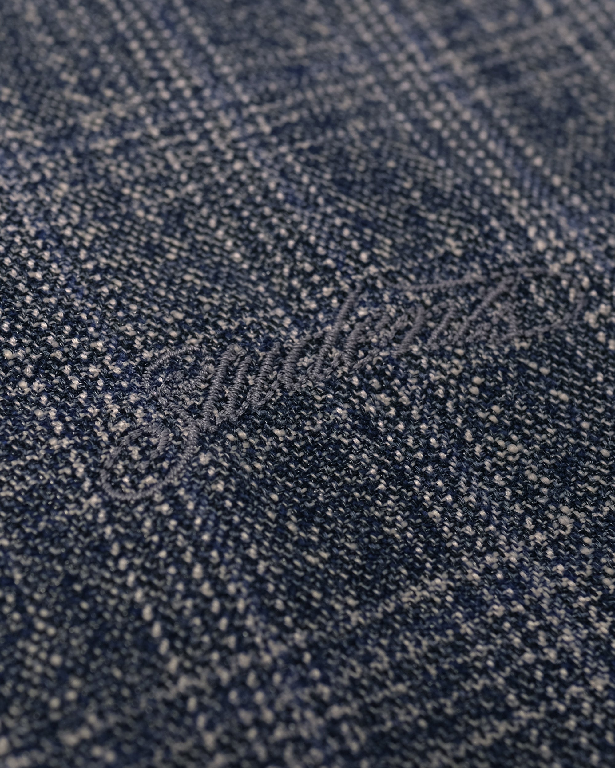 Close-up of blue denim fabric with a brand logo.