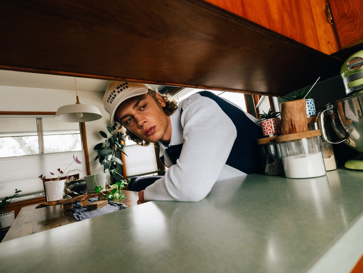 Person leaning over a counter in a kitchen setting