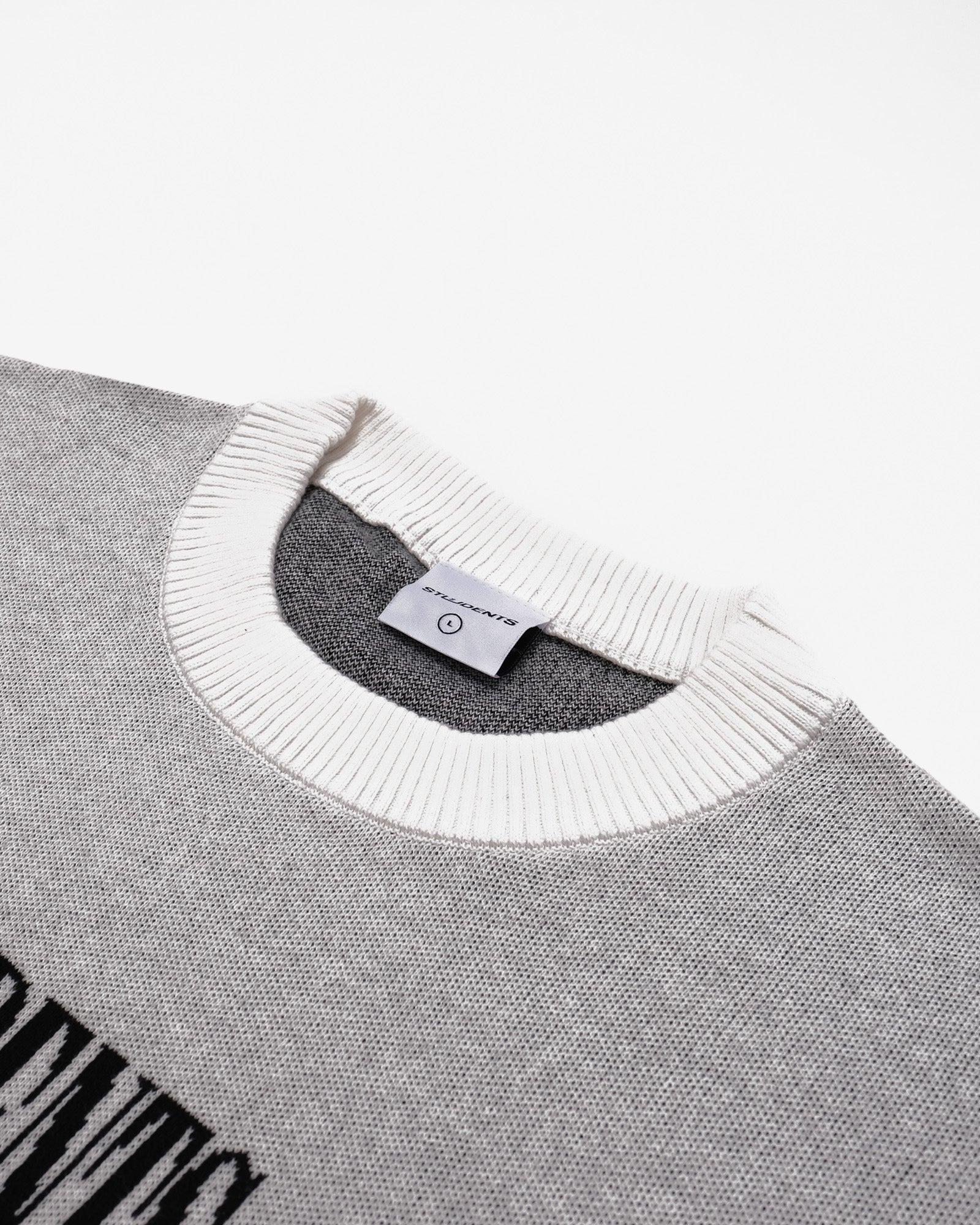 Gray sweater with white collar and brand label on a white background