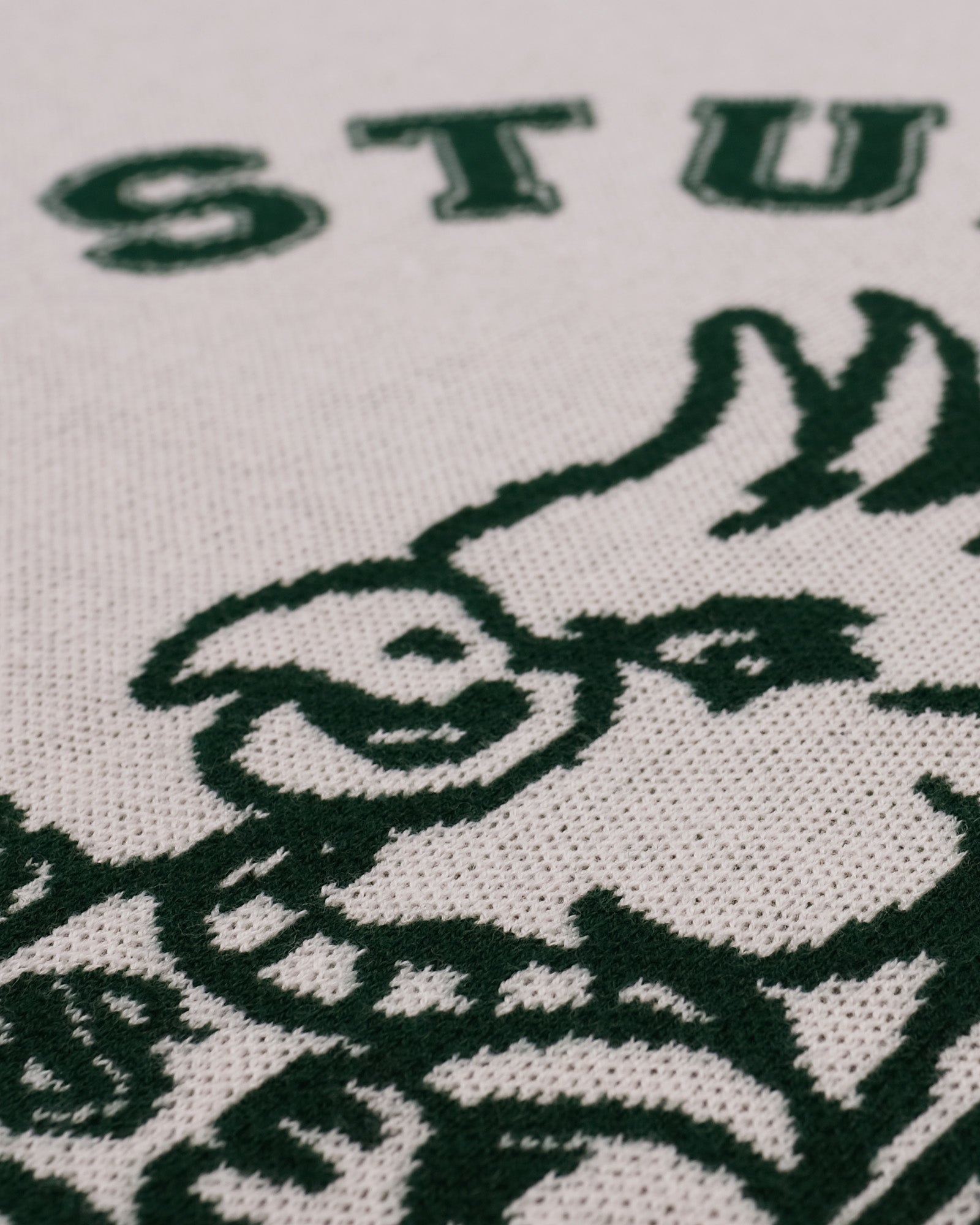 Close-up of a logo with a stylized face and 'STU' text on a white background