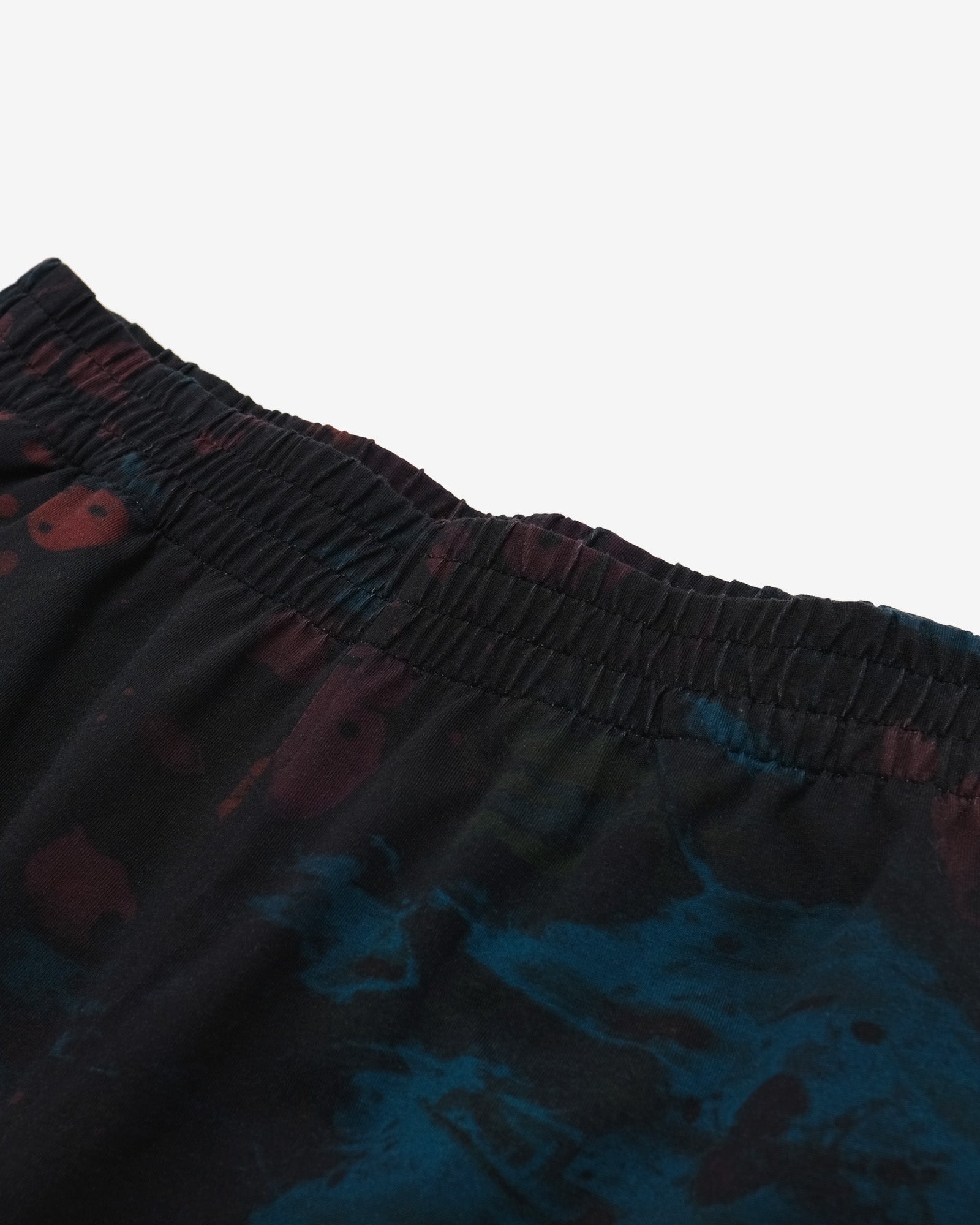 Close-up of dark shorts with a pattern on a light gray background