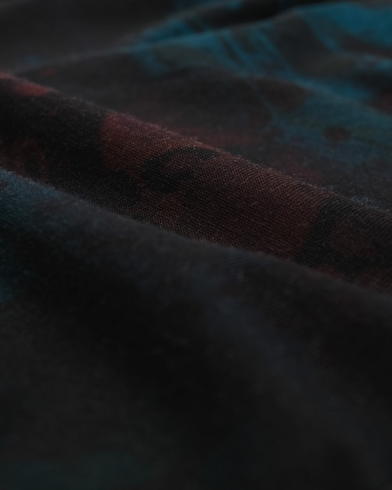 Close-up of textured fabric with a checkered pattern in dark colors.