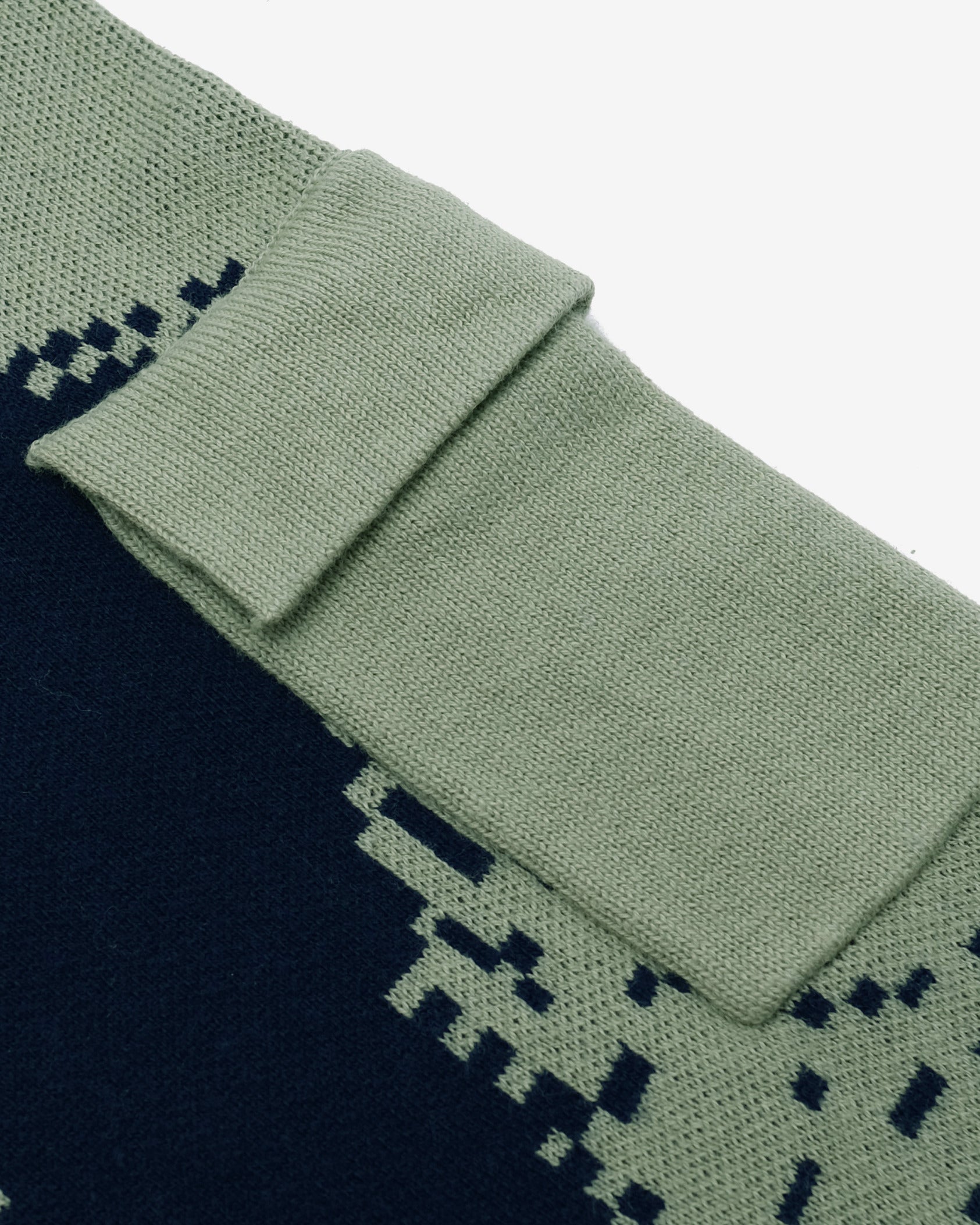 Close-up of green and navy patterned socks on a light gray background