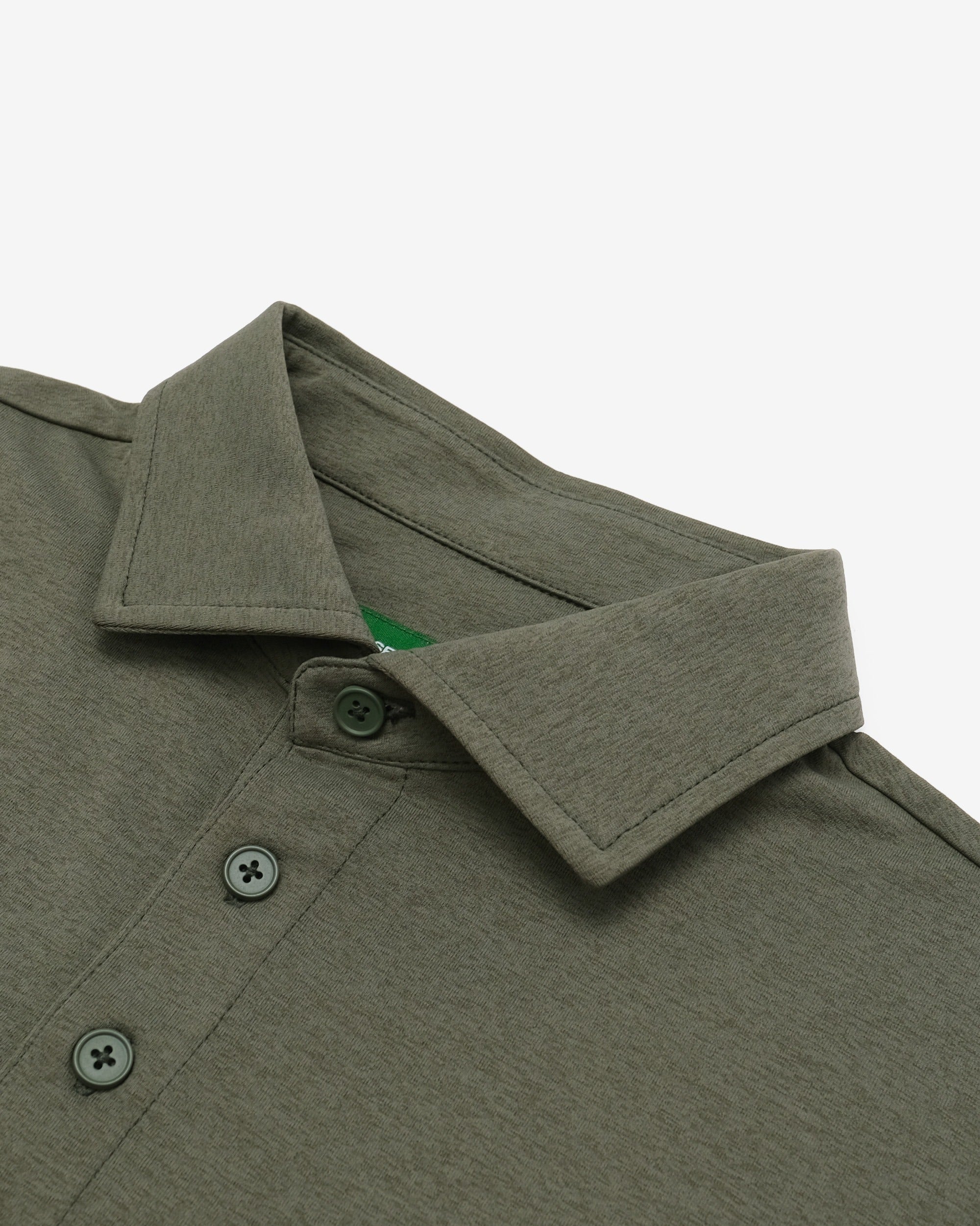Close-up of a green jacket collar with buttons on a white background