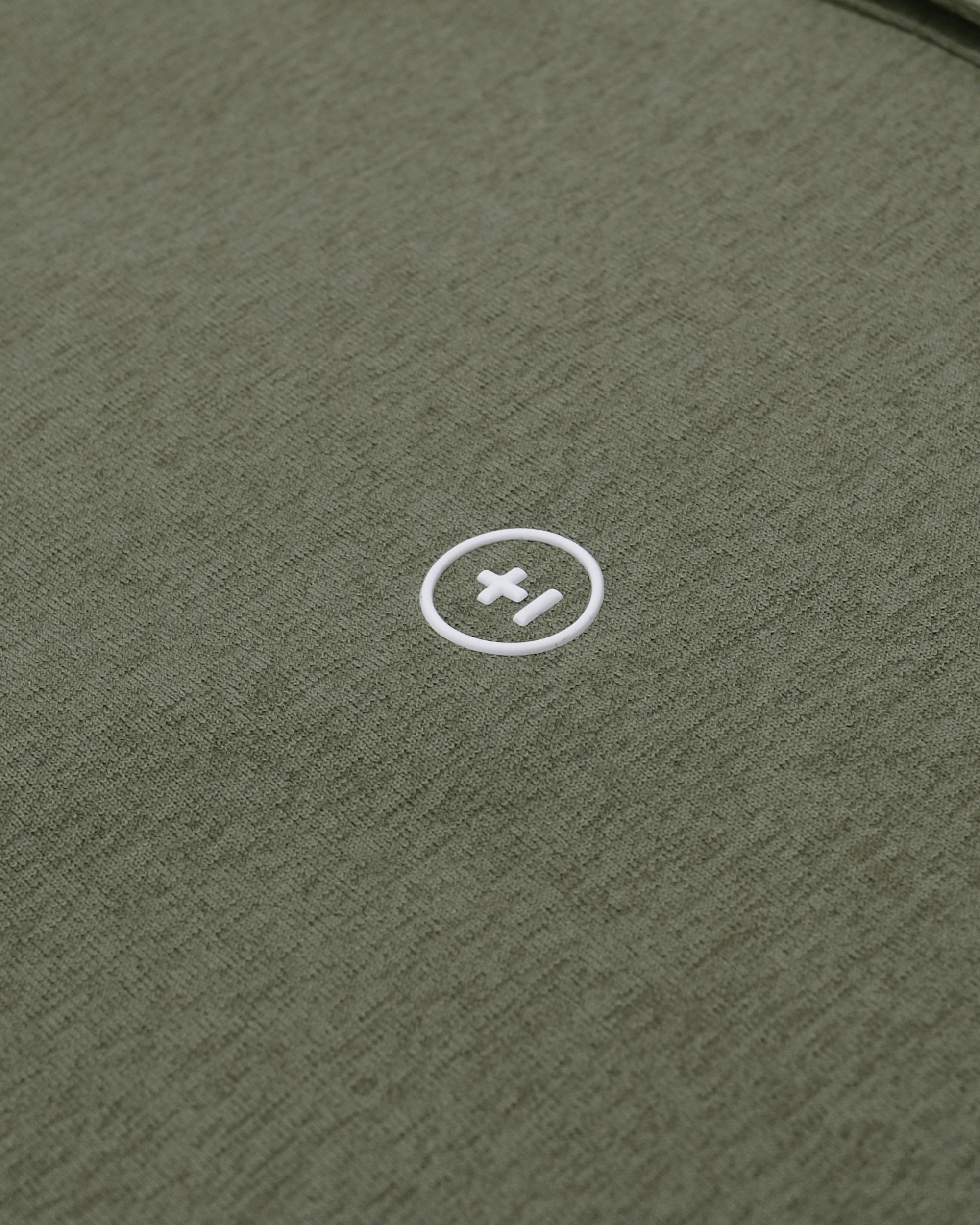 Close-up of a green textured surface with a white logo in the center.
