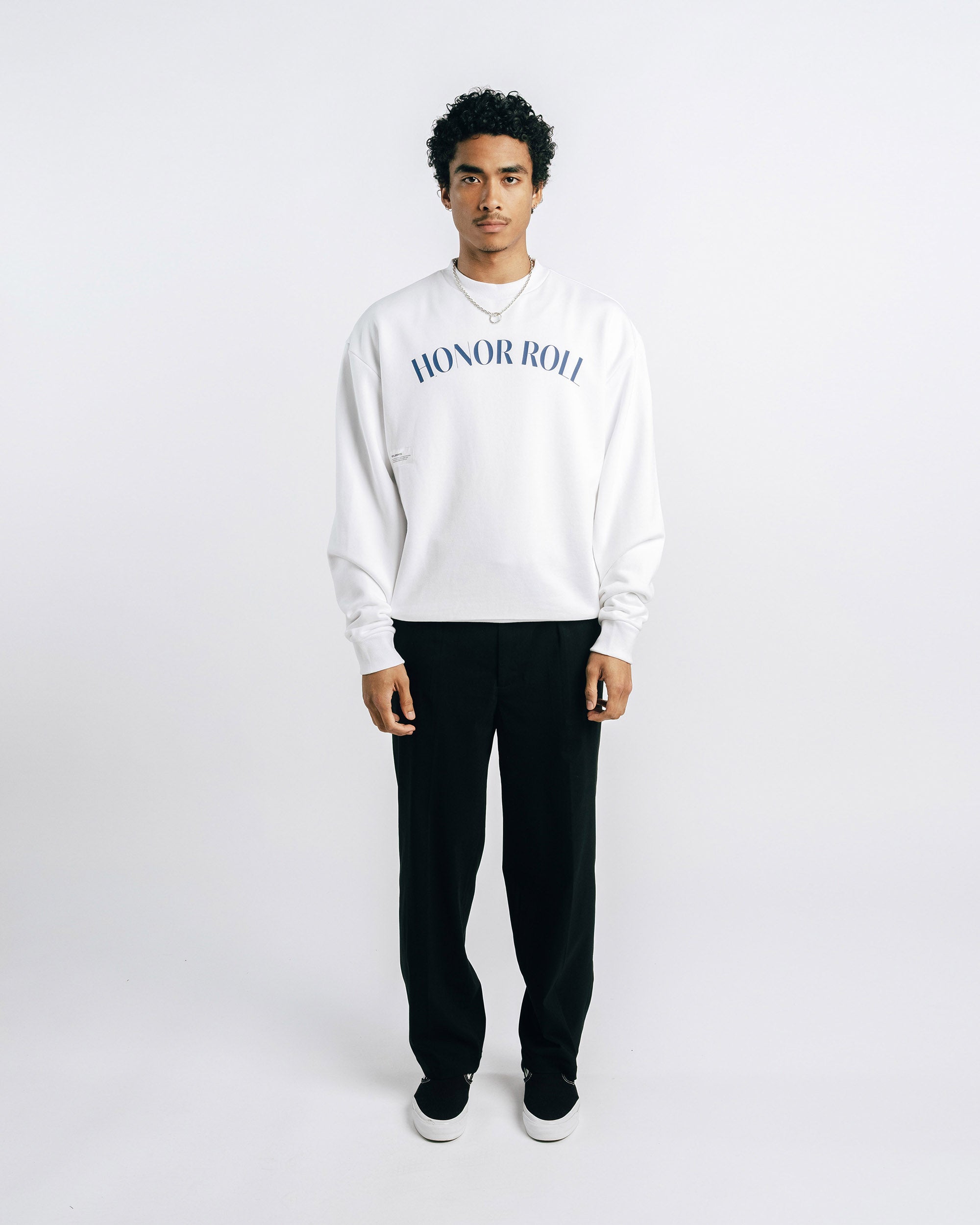 Person wearing a white sweatshirt with 'Honor Roll' text on a plain background