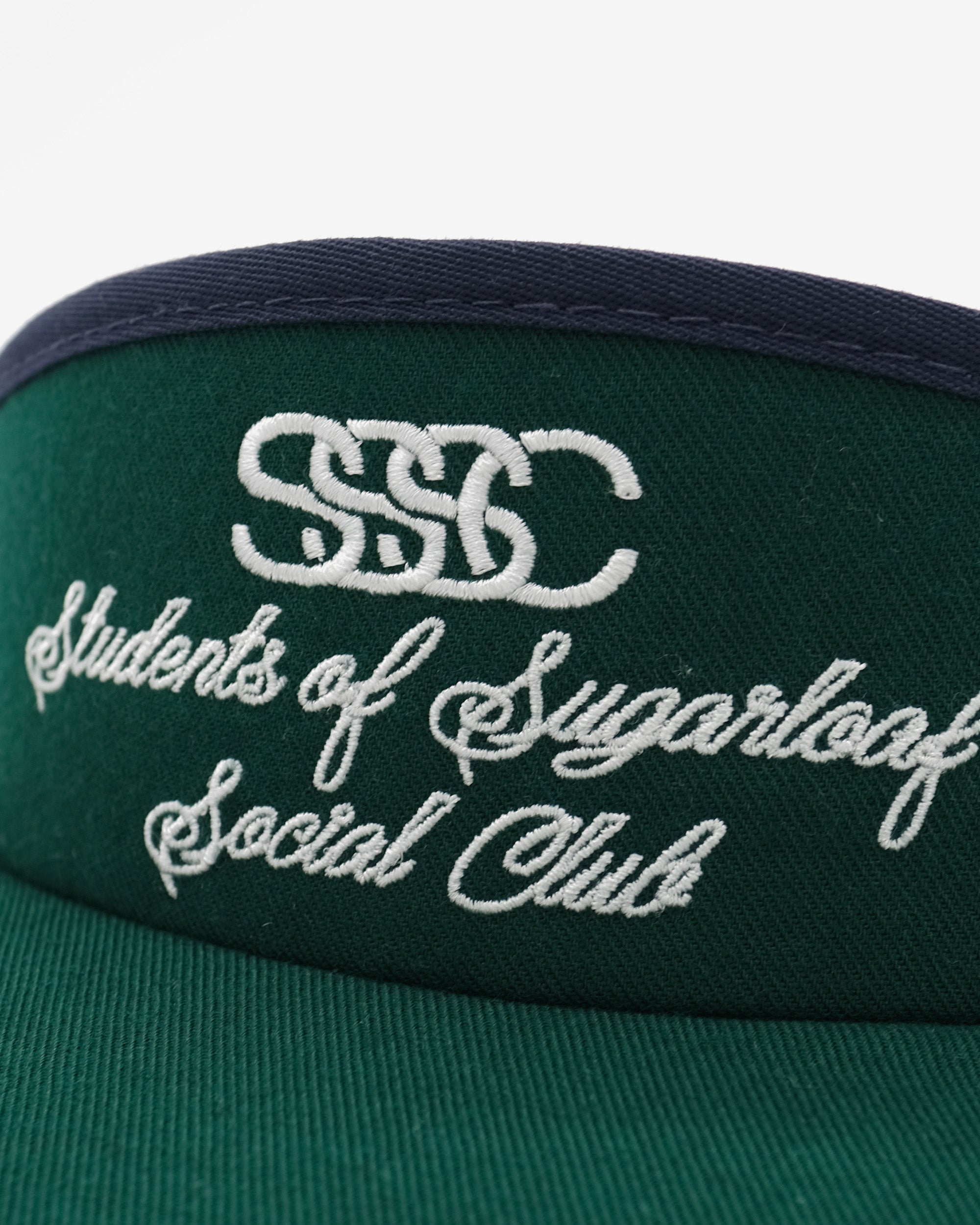 Green visor with embroidered text and logo on a white background