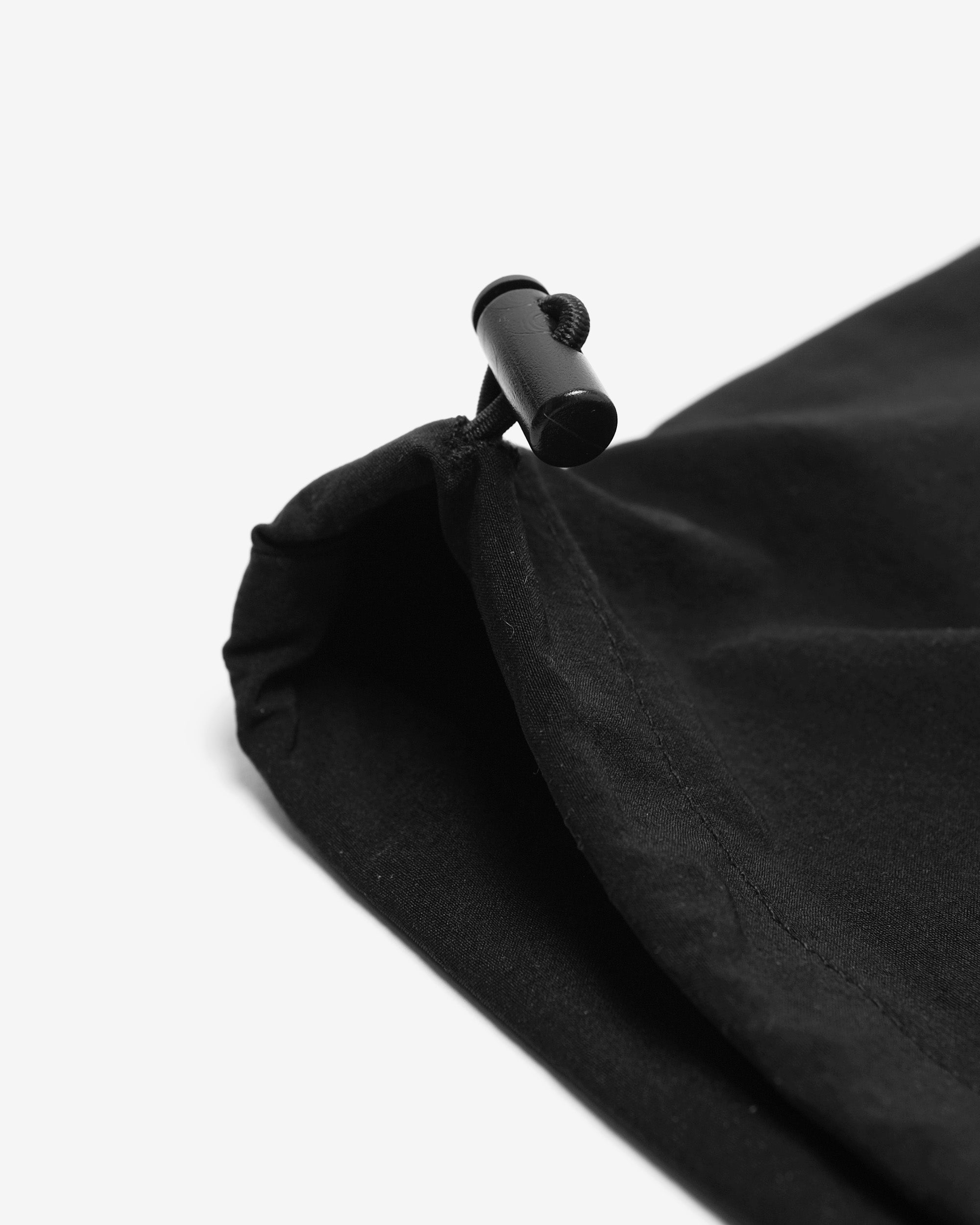 Close-up of a black drawstring bag on a white background