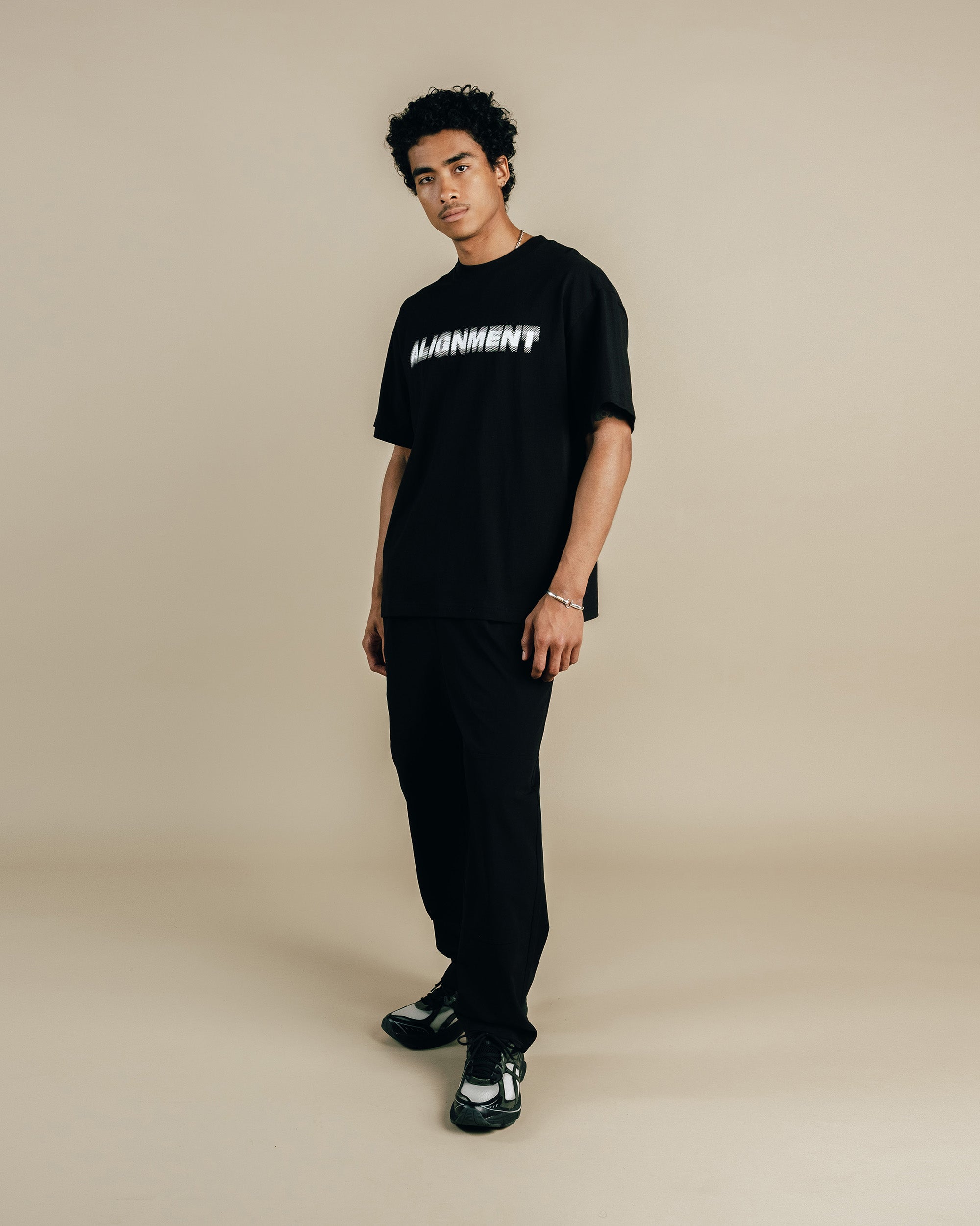 Person wearing a black t-shirt with white text on a beige background