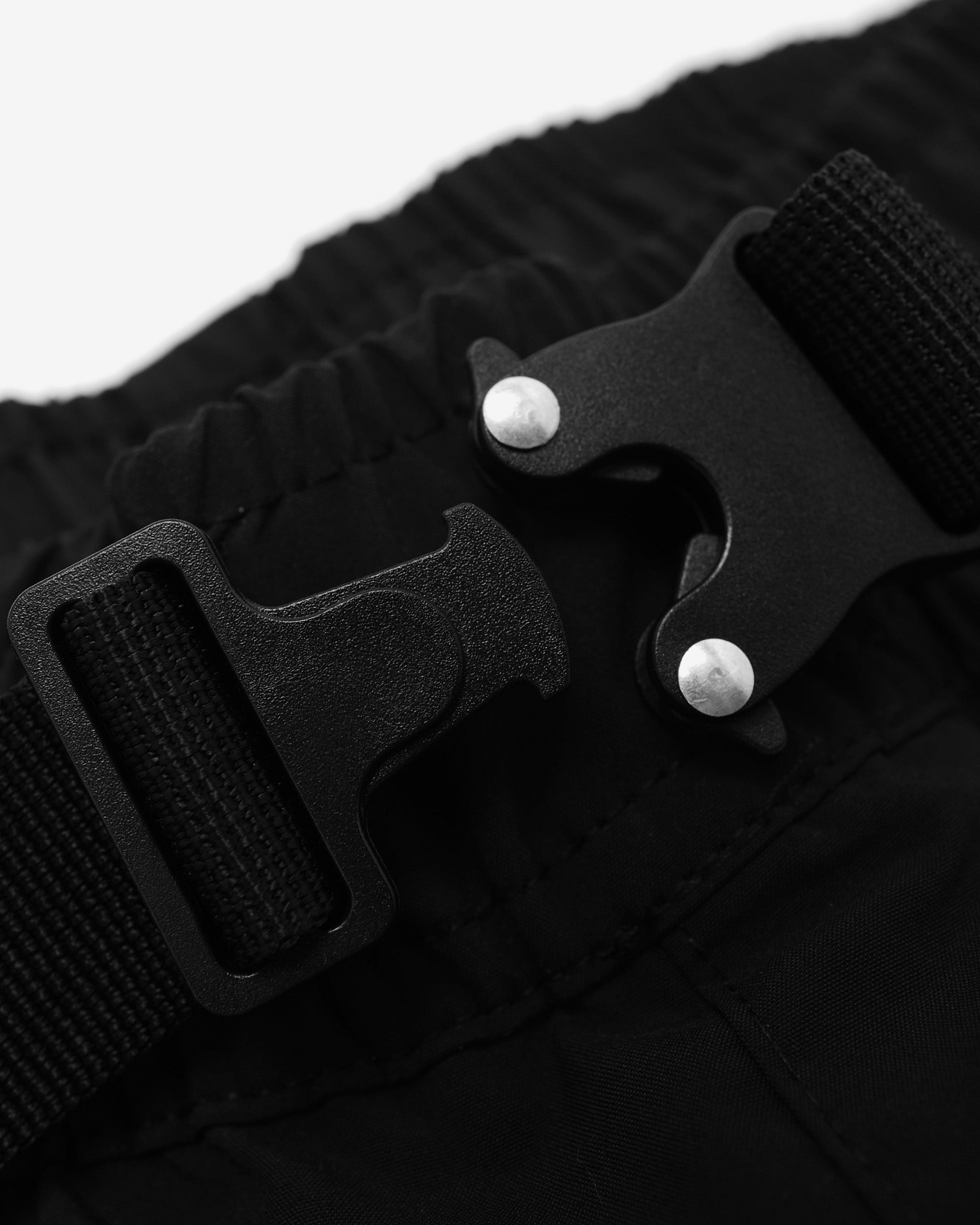 Close-up of a black belt with a buckle on a white background