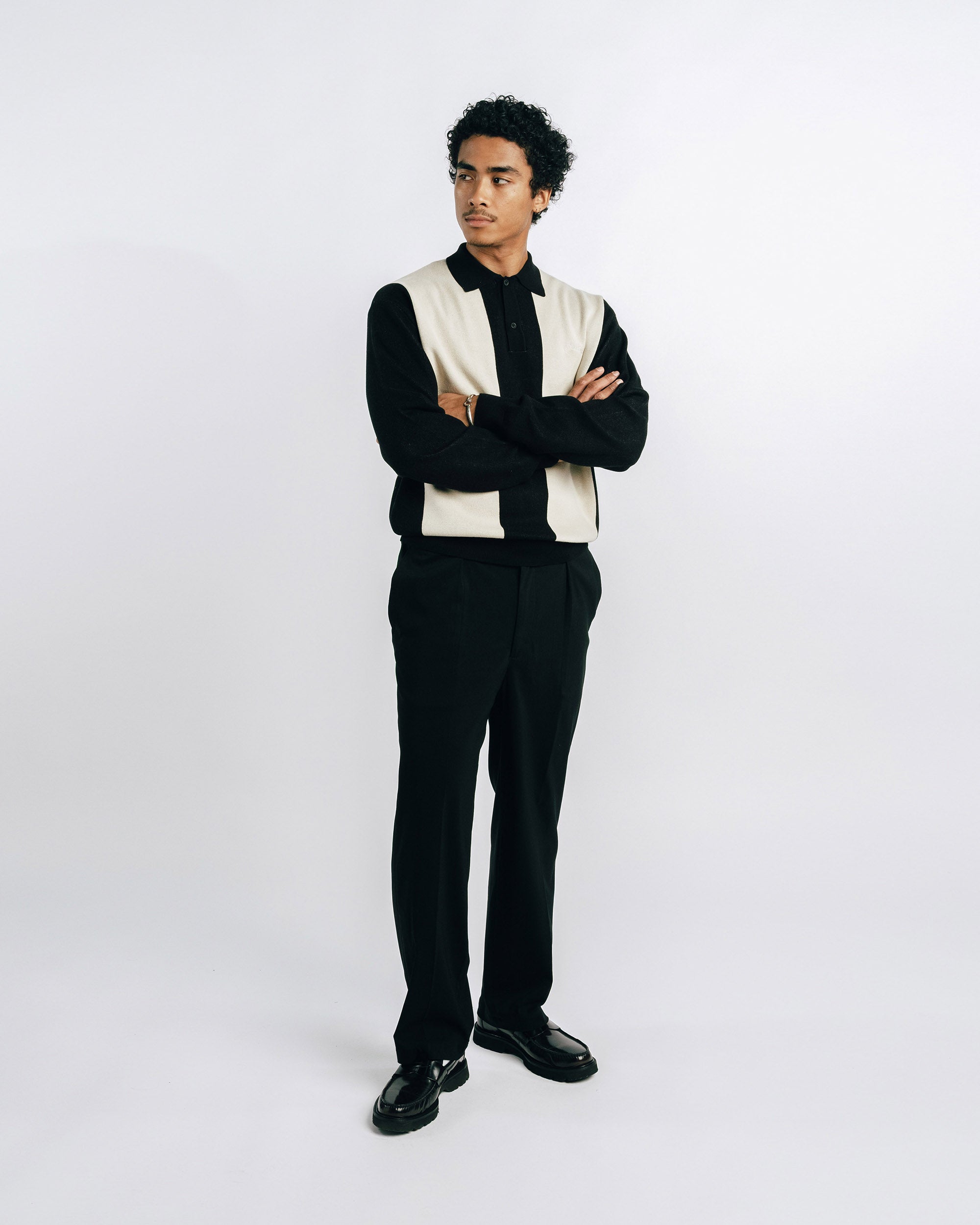 Man wearing a black suit with a white vest on a white background