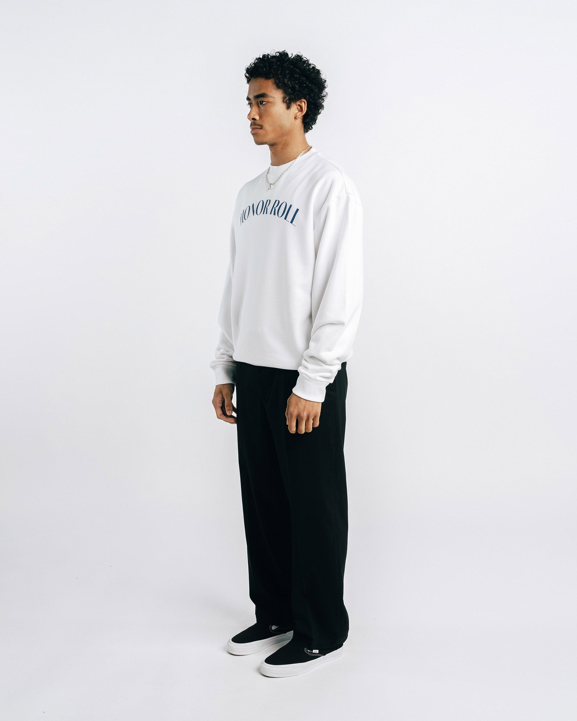 Person wearing a white sweatshirt with 'Honor Roll' text on a plain background