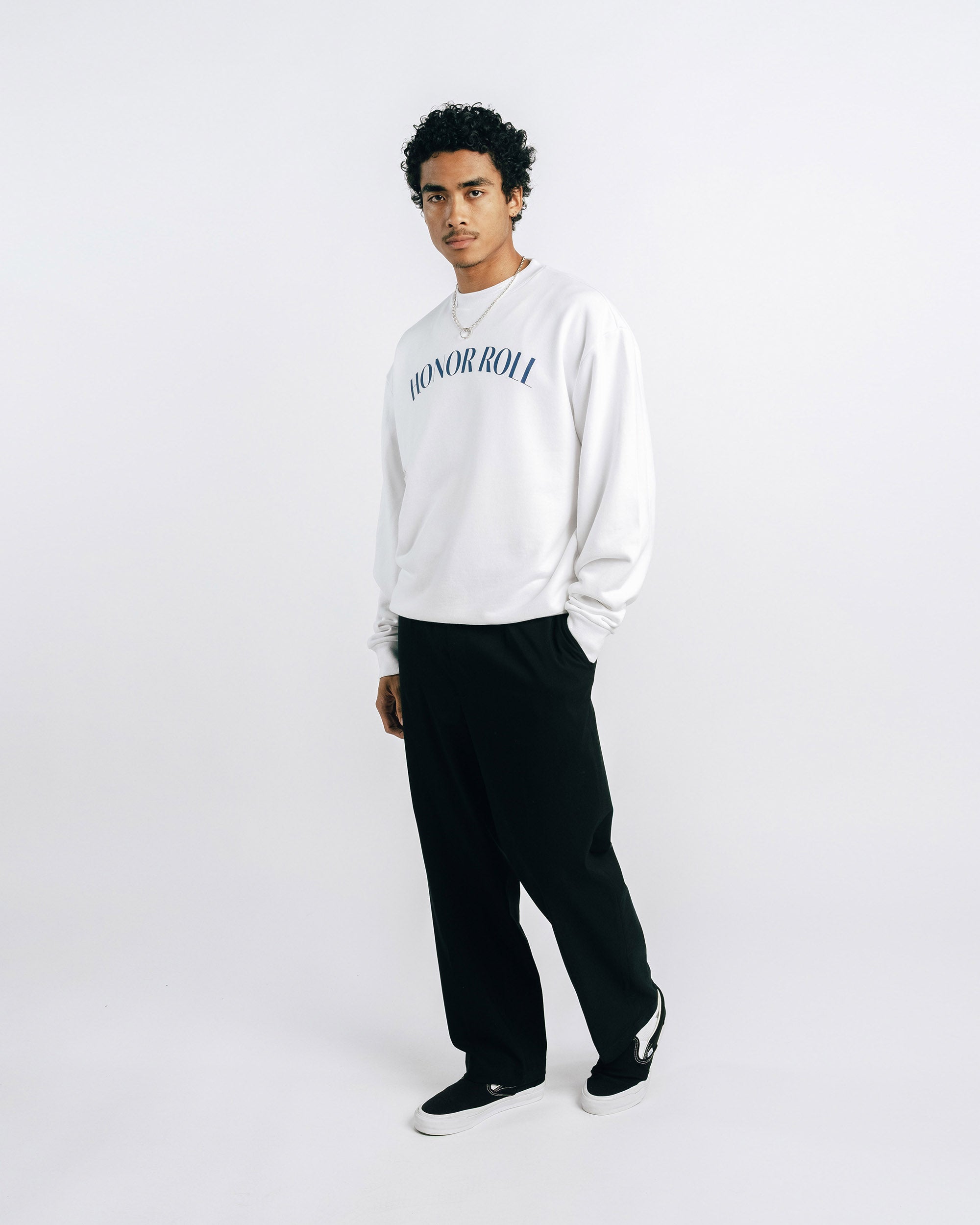 Person wearing a white sweatshirt with 'Honor Roll' text on a plain background