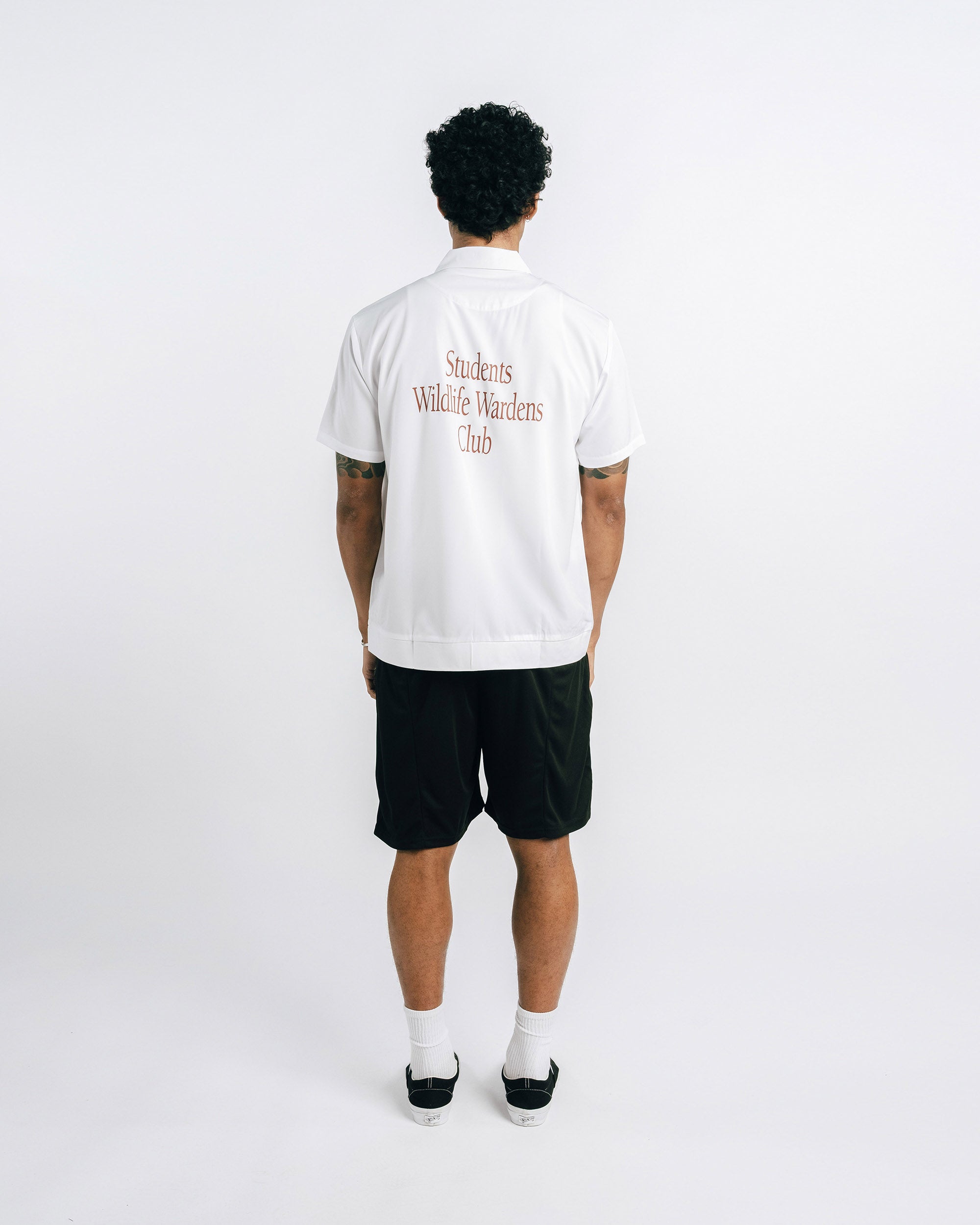 Person wearing a white t-shirt with text on the back against a white background