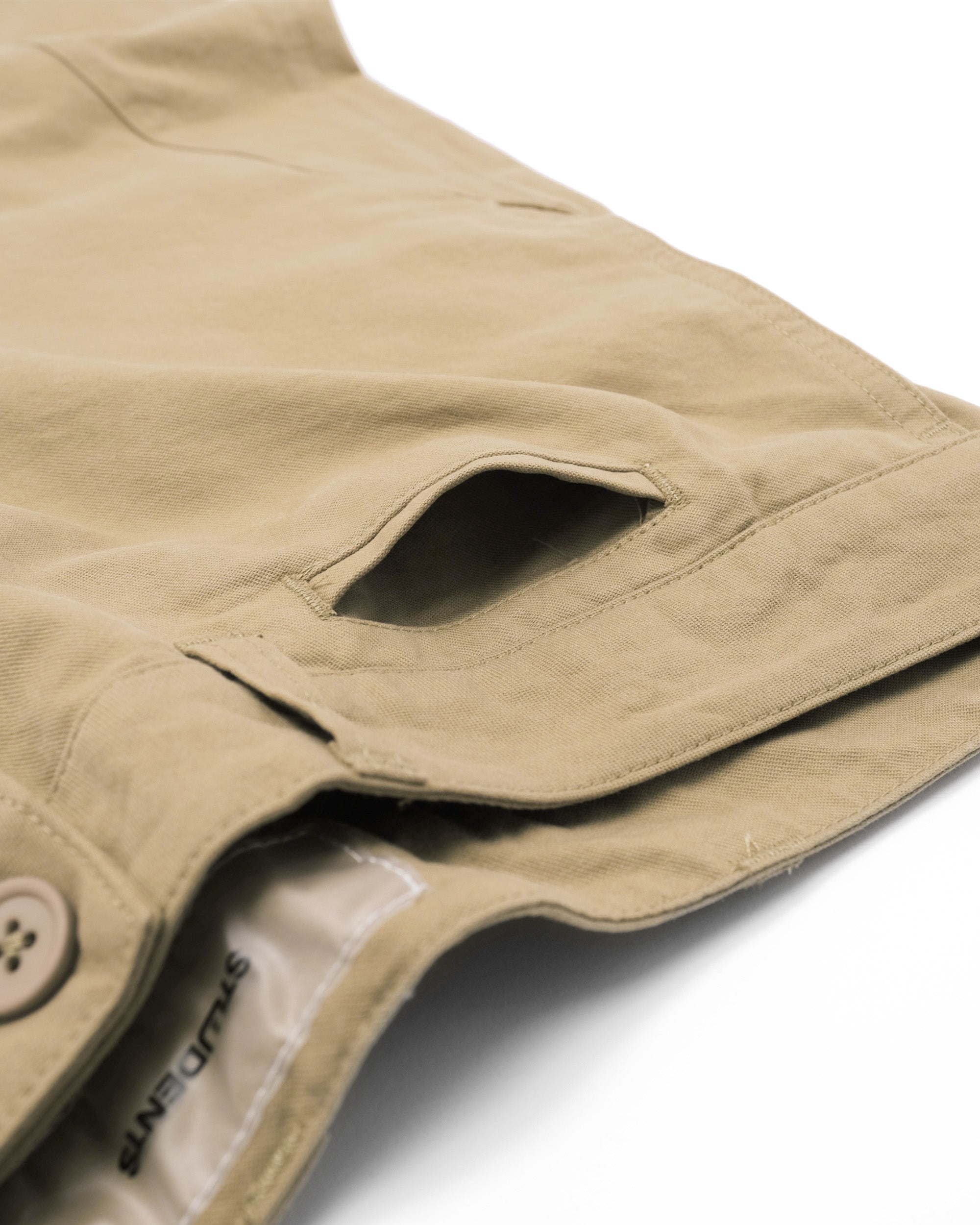 Close-up of a beige jacket with a button and brand logo on a white background