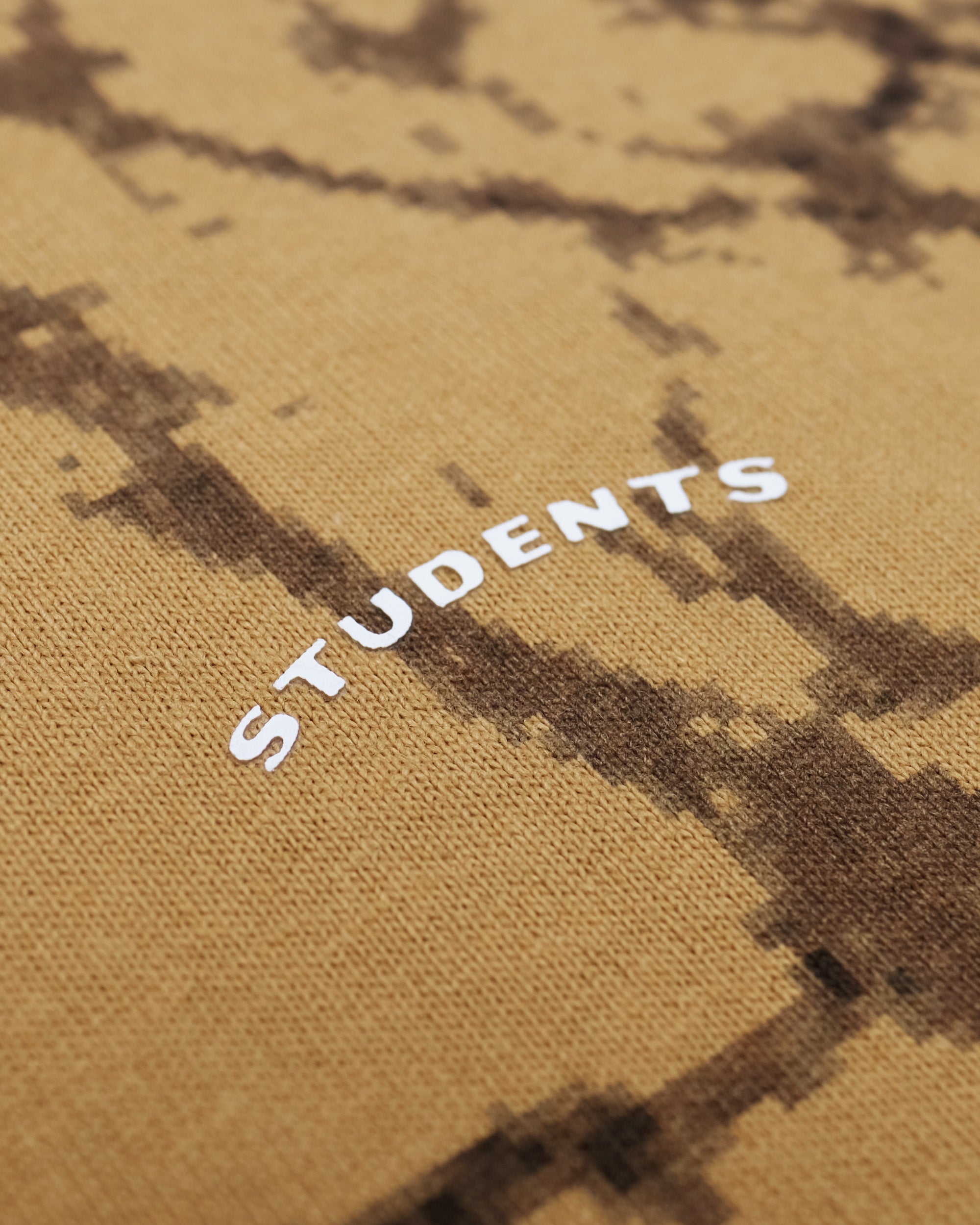 Text 'STUDENTS' on a brown fabric background with abstract patterns